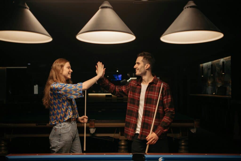 Frau dringt, beim Billiard spielen, in den persönlichen Raum des Mannes ein.